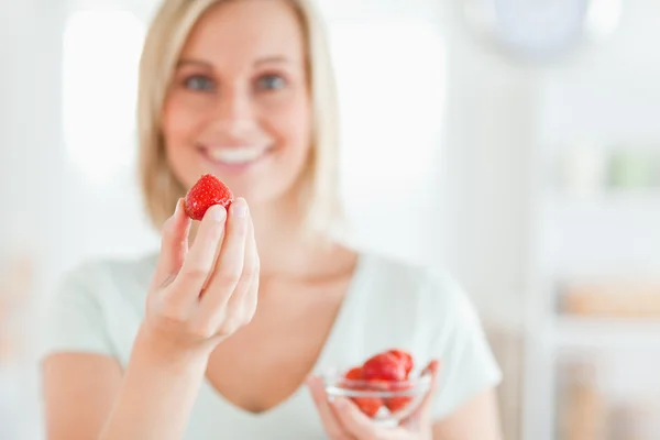 Nahaufnahme einer Frau, die gerne Erdbeeren isst und in die Sonne blickt — Stockfoto
