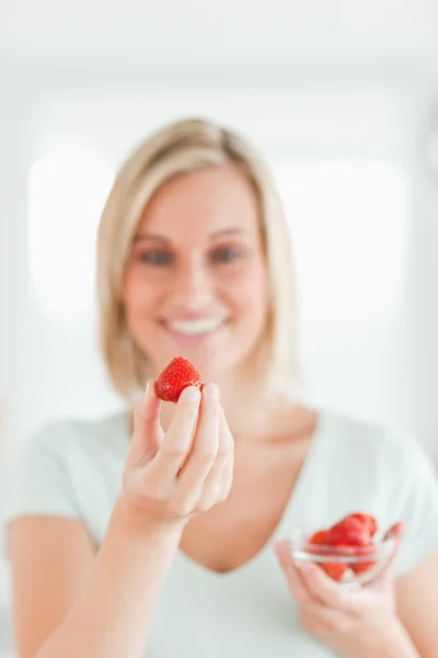 Mujer mirando fresa con placer — Foto de Stock