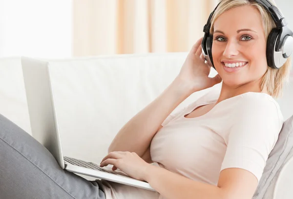 Blond-haired woman watching a movie on her laptop — Stock Photo, Image