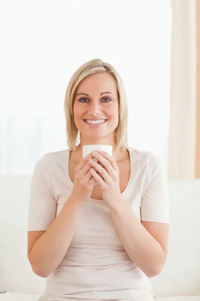 一个微笑的女人抱着一杯茶的肖像 — 图库照片
