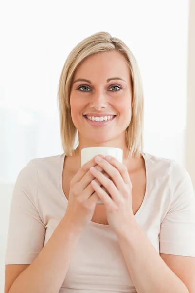 Πορτρέτο του ένα χαμογελαστό γυναίκα, κρατώντας ένα φλιτζάνι καφέ — Φωτογραφία Αρχείου