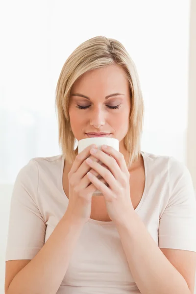 Porträt einer Frau, die ihre Tasse Kaffee riecht — Stockfoto