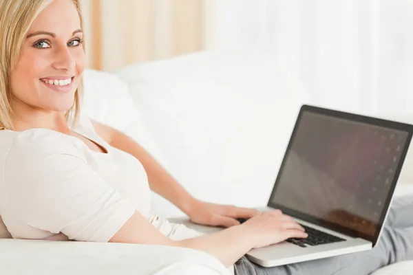 Närbild på en blond kvinna med en bärbar dator — Stockfoto