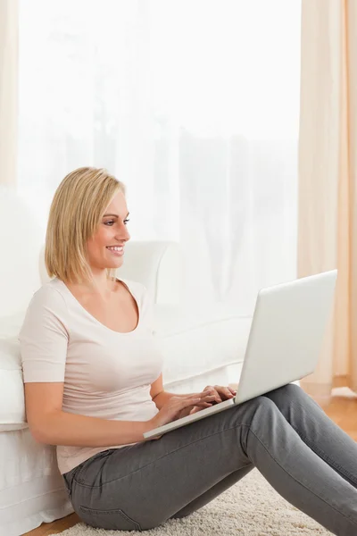 Portret van een blonde vrouw met behulp van een laptop — Stockfoto