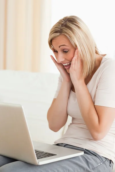 Задоволена жінка дивиться на ноутбук — стокове фото
