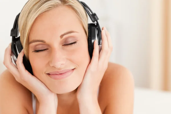 Close up de uma mulher encantada usando fones de ouvido — Fotografia de Stock