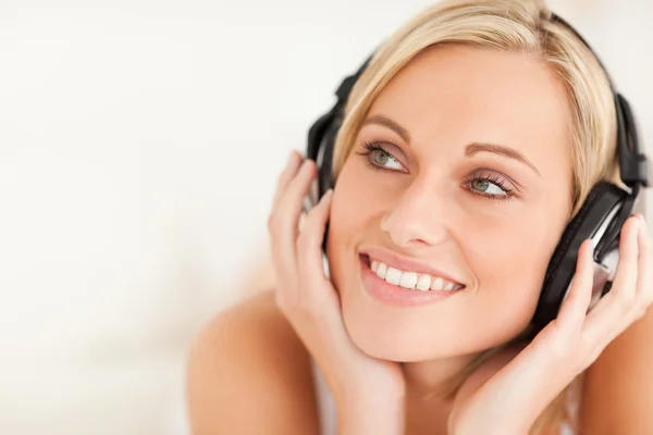 Close up de uma mulher sorridente usando fones de ouvido — Fotografia de Stock