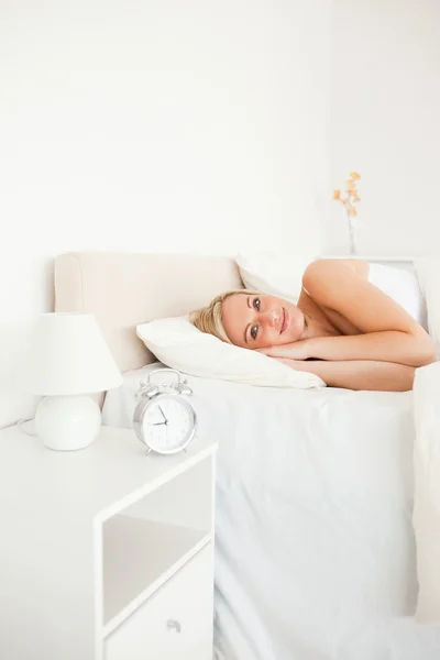 Egy nő felébred, és egy ébresztőóra portréja — Stock Fotó