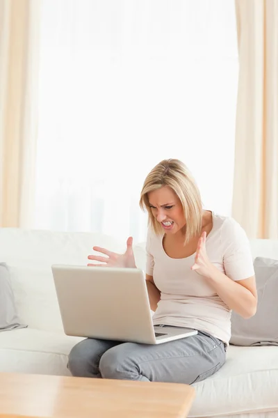Potrait de uma mulher loira chateada usando um laptop — Fotografia de Stock