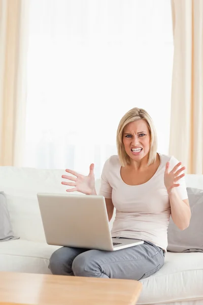 Πορτραίτο ενός θυμωμένη ξανθιά γυναίκα χρησιμοποιώντας ένα φορητό υπολογιστή — Φωτογραφία Αρχείου