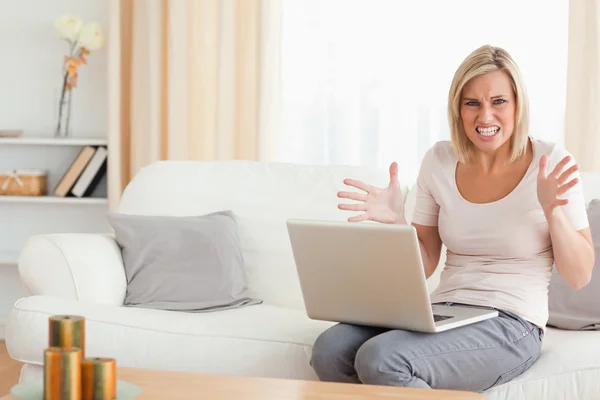 Mulher loira irritada usando um laptop — Fotografia de Stock