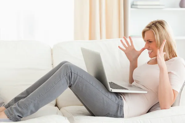 Unhappy blonde woman having trouble with her laptop — Stock Photo, Image