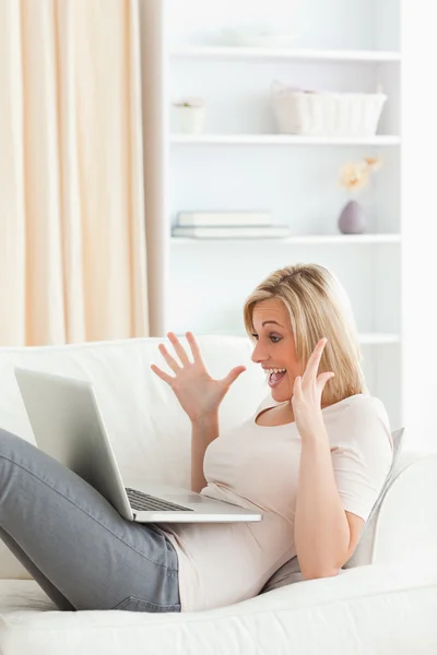 Portrait of an amazed woman using her laptop — Stock Photo, Image