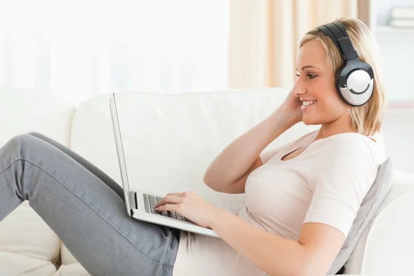 Femme blonde regardant un film avec son ordinateur portable — Photo
