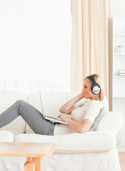 Portrait of a smling woman watching a movie with her laptop — Stock Photo, Image
