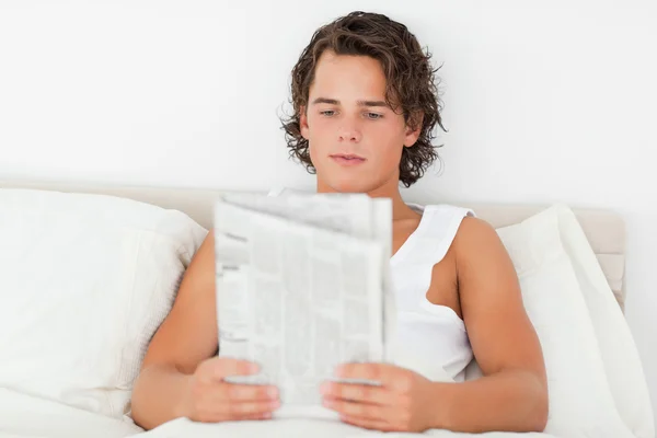 Jonge man die een krant leest — Stockfoto