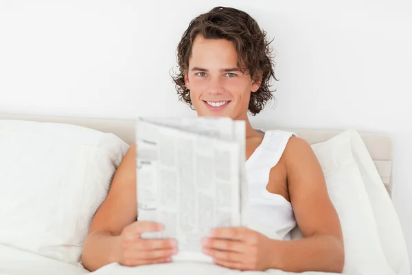 Молодой человек держит газету — стоковое фото