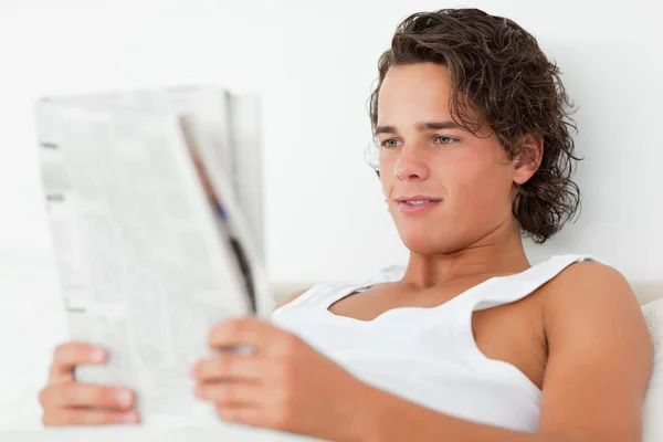 Närbild av en ung man läser en tidning — Stockfoto
