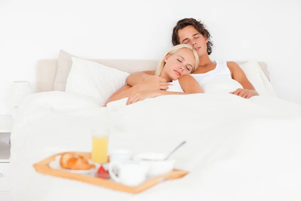 Schlafendes Paar mit dem Frühstück auf einem Tablett — Stockfoto