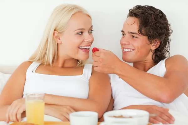 Bonito homem dando um morango para sua namorada — Fotografia de Stock