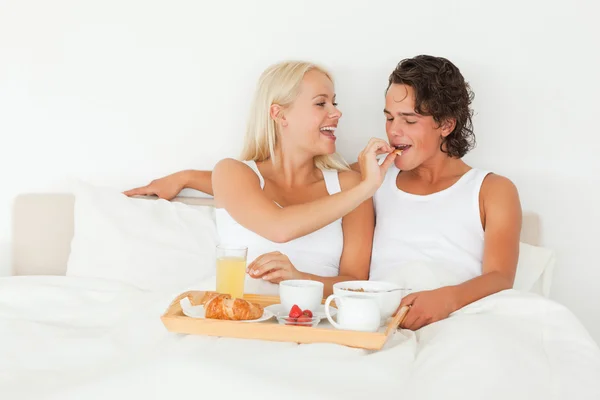 Frau gibt ihrem Verlobten ein Stück Croissant — Stockfoto