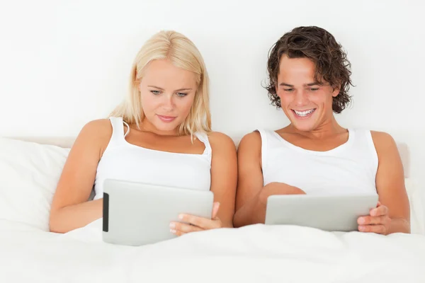 Молодая пара с помощью планшетных компьютеров — стоковое фото