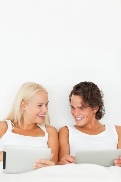 Портрет пары улыбающихся с помощью планшетных компьютеров — стоковое фото