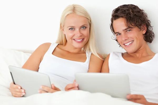Tablet bilgisayarlar ile genç bir çift — Stok fotoğraf
