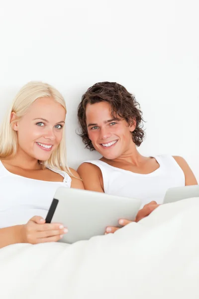 Портрет счастливой пары с помощью планшетных компьютеров — стоковое фото
