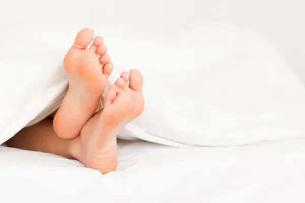 Füße im Bett — Stockfoto