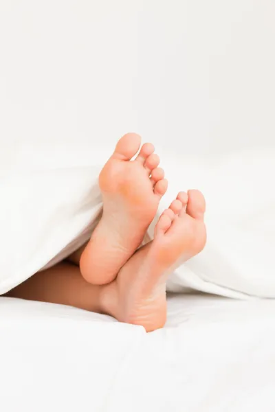 Retrato de pernas em uma cama — Fotografia de Stock