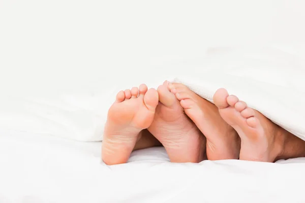 Fyra fötter i en säng — Stockfoto