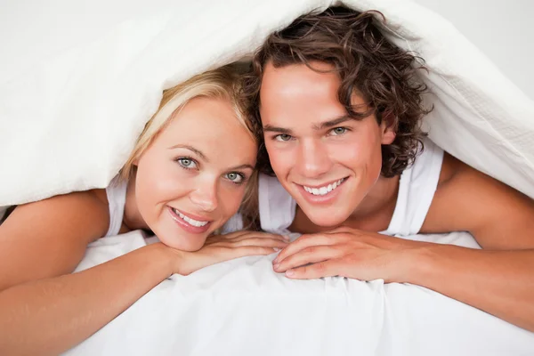 Paar unter einer Bettdecke — Stockfoto
