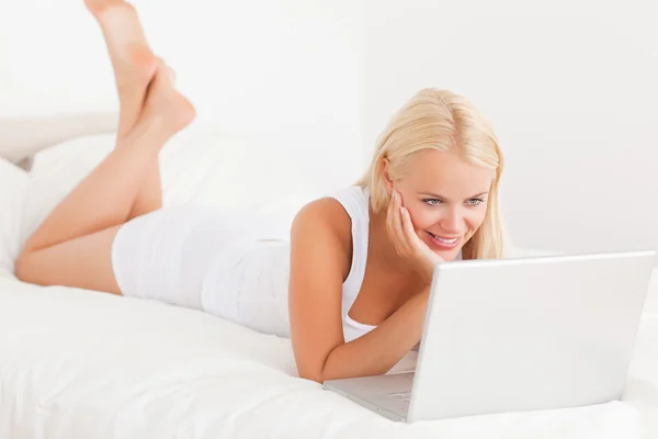 Gülümseyen kadın dizüstü bilgisayar kullanıyor. — Stok fotoğraf