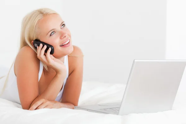 Frau am Telefon mit Laptop — Stockfoto