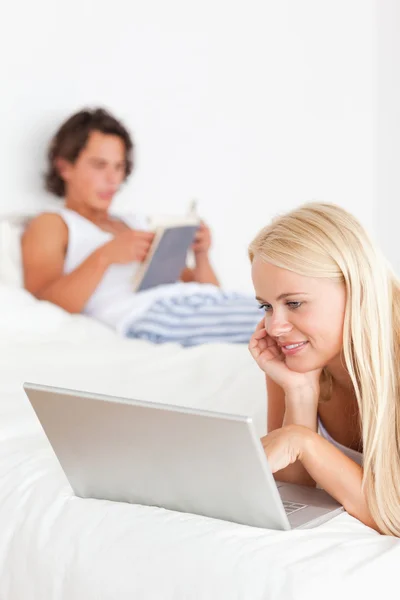 Portrait of a woman using a notebook while her fiance is reading — Stock Photo, Image
