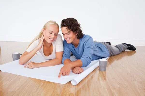 Young couple looking at a plan — Stock Photo, Image