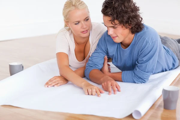 Couple talking about their future room with a plan — Stock Photo, Image
