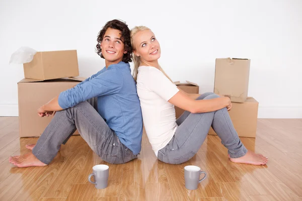Lovely couple sitting on the floor — Stock Photo, Image
