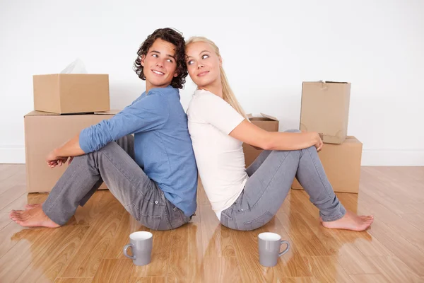 Nettes Paar sitzt auf dem Fußboden — Stockfoto