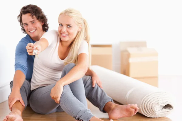 Woman sitting with her boyfriend giving keys — Stock Photo, Image