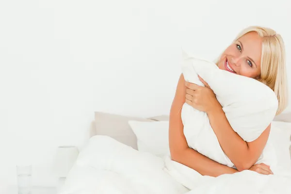 Mujer linda sosteniendo una almohada — Foto de Stock