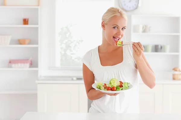 Blond vrouwtje eet een salade — Stockfoto