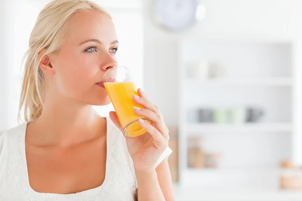 Close up of a blonde woman drinking juice — Stock Photo, Image