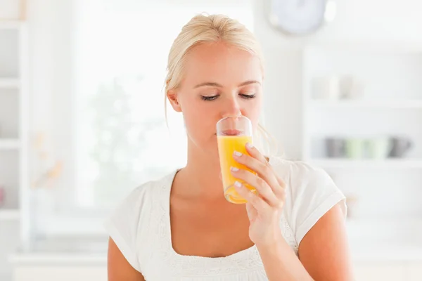 Mujer rubia bebiendo jugo de naranja — Foto de Stock