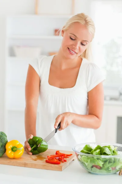 Blonde woman slicing pepper — Stock Photo, Image