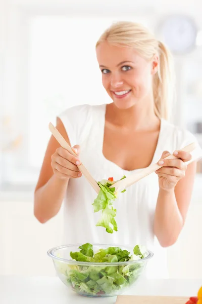 Porträt einer Frau, die einen Salat mixt — Stockfoto