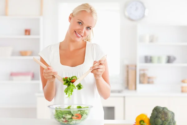 Leuke vrouw die een salade mengt — Stockfoto