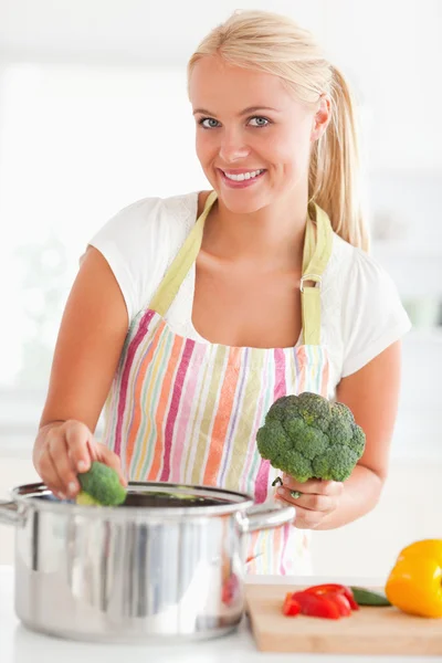 Portrait of a smiling woman putting cabbage on water — Stock Photo, Image