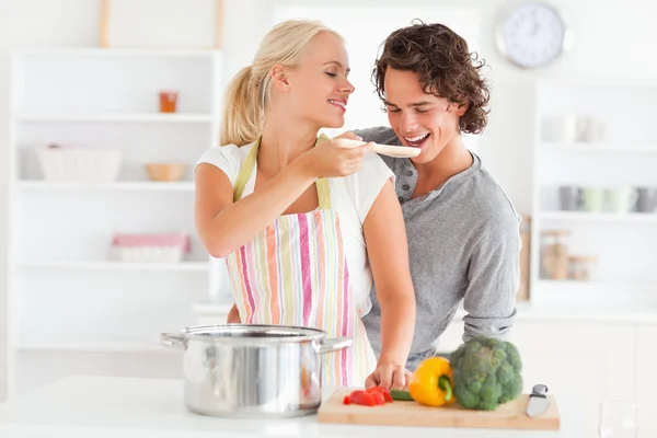 Kvinna att göra hennes fästman smaka hennes måltid — Stockfoto